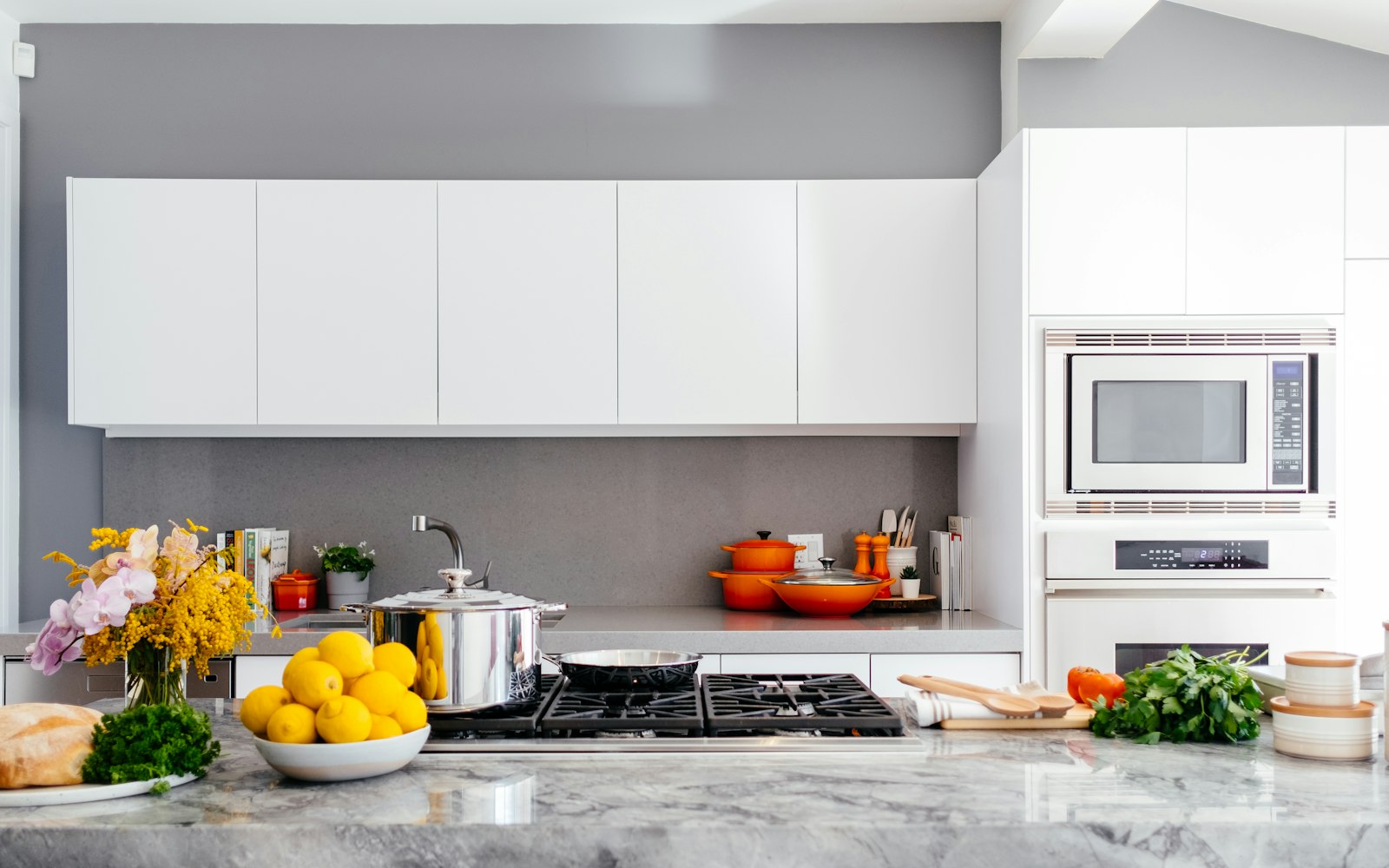 White modular kitchen with warm copper cookware accents