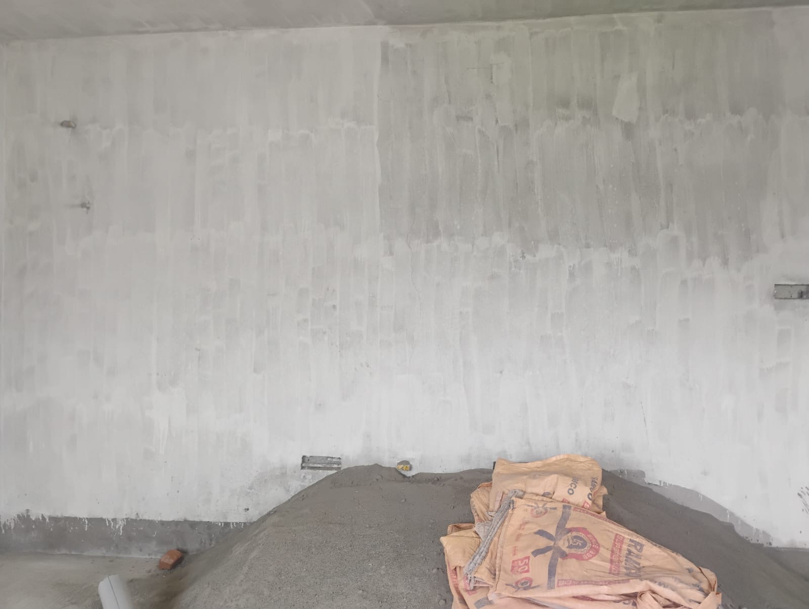 Wall being prepared, cement bags on the floor