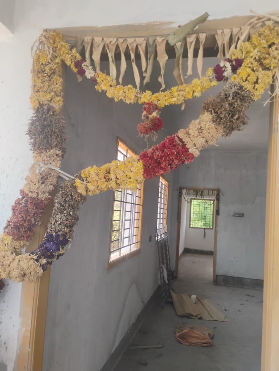The house garlanded with marigolds on handover day